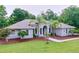 Inviting one-story home with lush lawn, landscaped garden beds, complemented with palm trees for curb appeal at 27511 Hialeah Way, Wesley Chapel, FL 33544