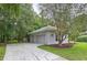 Spacious two-car garage, long driveway with mature trees providing shade and curb appeal at 27511 Hialeah Way, Wesley Chapel, FL 33544