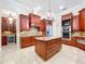 Spacious kitchen featuring custom wood cabinets, granite countertops, and a large center island with drawers at 27511 Hialeah Way, Wesley Chapel, FL 33544