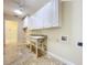 Bright laundry room features ample storage cabinets, granite countertops, sink, and tile flooring at 27511 Hialeah Way, Wesley Chapel, FL 33544