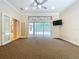 Spacious living room with views of the lanai, a modern ceiling fan, and glass doors to another room at 27511 Hialeah Way, Wesley Chapel, FL 33544