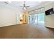 Open-concept living room boasts a ceiling fan, glass doors to the lanai, and easy access to the kitchen at 27511 Hialeah Way, Wesley Chapel, FL 33544