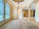 Spacious living room with large windows, tray ceiling, and elegant columns at 27511 Hialeah Way, Wesley Chapel, FL 33544