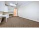 Spacious office features built-in shelving, a work space, ceiling fan, and carpeted floors at 27511 Hialeah Way, Wesley Chapel, FL 33544
