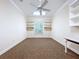 Bright office with carpet, white shelving and desktop, a ceiling fan and large windows at 27511 Hialeah Way, Wesley Chapel, FL 33544