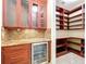 Walk-in pantry with custom wood shelving and cabinets adjacent to wine fridge for convenient storage at 27511 Hialeah Way, Wesley Chapel, FL 33544