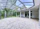 Enclosed patio features a spacious area, neutral colored brick floor and a lovely view of the wooded backyard at 27511 Hialeah Way, Wesley Chapel, FL 33544