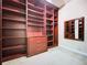 Spacious walk-in closet with custom built-in shelving, drawers, and a full-length mirror at 27511 Hialeah Way, Wesley Chapel, FL 33544