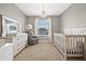 Charming Bedroom featuring soft colors, a crib, changing table, and elegant chandelier at 2771 Suncoast Blend Dr, Odessa, FL 33556