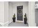 Inviting front entrance featuring a decorative wreath, potted spiral topiary and a neutral colored door mat at 2771 Suncoast Blend Dr, Odessa, FL 33556