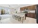 Open-concept kitchen featuring granite countertops, wooden cabinets, island seating and stainless steel appliances at 2771 Suncoast Blend Dr, Odessa, FL 33556