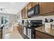 Well-equipped kitchen featuring granite countertops, wooden cabinets, island seating and stainless steel appliances at 2771 Suncoast Blend Dr, Odessa, FL 33556