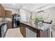 Well-equipped kitchen featuring granite countertops, wooden cabinets, island seating and stainless steel appliances at 2771 Suncoast Blend Dr, Odessa, FL 33556