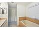 Bright bathroom featuring a tiled tub, neutral tones, and closet for optimal comfort at 2990 Longbrooke Way, Clearwater, FL 33760