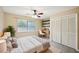 Bright bedroom featuring a ceiling fan, closet, desk, and a large window with scenic views at 2990 Longbrooke Way, Clearwater, FL 33760