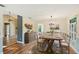 Charming dining room with wood floors, large windows, chandelier, and rustic wooden table at 2990 Longbrooke Way, Clearwater, FL 33760