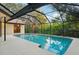 Enclosed pool area featuring a spacious patio, refreshing pool, and serene backyard views at 2990 Longbrooke Way, Clearwater, FL 33760