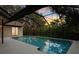 Enclosed pool area featuring a spacious patio, refreshing pool, and serene backyard views at 2990 Longbrooke Way, Clearwater, FL 33760