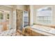 Elegant bathroom featuring tiled shower, garden tub, and neutral color scheme at 3062 Sutton Woods Dr, Plant City, FL 33566