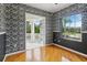 Bedroom with hardwood floors, patterned wallpaper, and an outdoor balcony at 3062 Sutton Woods Dr, Plant City, FL 33566