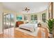 Bright bedroom with multiple windows, hardwood floors, and a sliding glass door to the pool area at 3062 Sutton Woods Dr, Plant City, FL 33566