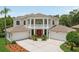 Elegant home exterior featuring classic architectural details, a grand entrance, and a spacious three-car garage at 3062 Sutton Woods Dr, Plant City, FL 33566