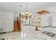 Bright and open foyer with marble floors, staircase, pillars, chandelier, and a glass table at 3062 Sutton Woods Dr, Plant City, FL 33566
