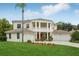 Charming two-story home with manicured front lawn and mature landscaping, including a palm tree at 3062 Sutton Woods Dr, Plant City, FL 33566