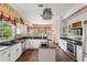 Large kitchen with stainless steel appliances, white cabinetry, and a stylish chandelier at 3062 Sutton Woods Dr, Plant City, FL 33566