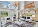 Bright living room boasting high ceilings, statement chandelier, mural, and views of outdoor pool at 3062 Sutton Woods Dr, Plant City, FL 33566