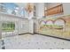 Open living room with high ceilings, a chandelier, marble floors, and sliding glass doors to the pool at 3062 Sutton Woods Dr, Plant City, FL 33566