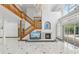 Bright living room featuring a fireplace, grand staircase, and large windows with backyard views at 3062 Sutton Woods Dr, Plant City, FL 33566