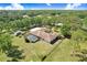Sprawling property featuring a fenced yard, a screened pool, mature trees, and a secondary structure in this aerial view at 3452 Forelock Rd, Tarpon Springs, FL 34688