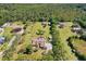 High aerial perspective revealing the home's layout, fenced-in pool, and surrounding wooded landscape at 3452 Forelock Rd, Tarpon Springs, FL 34688