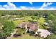 Sprawling property featuring a beautifully landscaped home, lush pastures, and scenic surroundings from an aerial perspective at 3452 Forelock Rd, Tarpon Springs, FL 34688