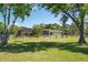 Expansive backyard of a home, featuring a large screened-in pool area and wooden perimeter fence at 3452 Forelock Rd, Tarpon Springs, FL 34688