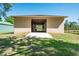 Exterior view of a barn with a concrete floor leading into the open-air stables, and a backdrop of a grassy field at 3452 Forelock Rd, Tarpon Springs, FL 34688