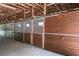 The barn showcases multiple horse stalls with wood panels and steel bars beneath an exposed wood beam ceiling at 3452 Forelock Rd, Tarpon Springs, FL 34688