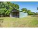 Exterior view of a large barn with steel construction, multiple horse stalls and lush green surroundings at 3452 Forelock Rd, Tarpon Springs, FL 34688