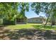 Exterior view of a horse property featuring a large barn and shade trees under a clear, sunny blue sky at 3452 Forelock Rd, Tarpon Springs, FL 34688