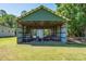 Outdoor barn featuring wooden beams, open walls and metal gates, with a large grass lawn at 3452 Forelock Rd, Tarpon Springs, FL 34688