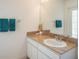 Bright bathroom featuring a granite countertop, sink, mirror, and wall-mounted towel rack at 3452 Forelock Rd, Tarpon Springs, FL 34688