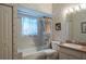 Bathroom with patterned wallpaper, shower-tub combo with a curtain, vanity, and framed artwork at 3452 Forelock Rd, Tarpon Springs, FL 34688