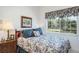 Bright bedroom featuring a large window offering scenic views, complemented by floral bedding and ample natural light at 3452 Forelock Rd, Tarpon Springs, FL 34688