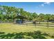 Blue Jeep parked under a wooden carport within a fenced yard, showcasing a functional outdoor space at 3452 Forelock Rd, Tarpon Springs, FL 34688