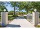 Gated entrance with a long driveway leading to a secluded home surrounded by beautiful landscaping at 3452 Forelock Rd, Tarpon Springs, FL 34688