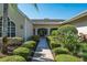 Front entrance of tan home with arched windows and manicured shrubbery at 3452 Forelock Rd, Tarpon Springs, FL 34688