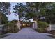 Home entrance with manicured landscaping, gated entrance and a flagpole featuring an American flag at 3452 Forelock Rd, Tarpon Springs, FL 34688