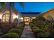 Inviting home entrance featuring a manicured walkway lined with lush shrubbery, enhancing curb appeal at twilight at 3452 Forelock Rd, Tarpon Springs, FL 34688