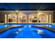 Screened in backyard swimming pool with sun shelf and expansive patio area for outdoor entertaining at twilight at 3452 Forelock Rd, Tarpon Springs, FL 34688